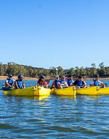 Imagen secundaria 2 - Arriba: Mayores y pequeños disfrutaron de las piraguas. Abajo izquierda: Preparándose para comenzar la actividad. Abajo derecha: Escuchando las indicaciones de los monitores