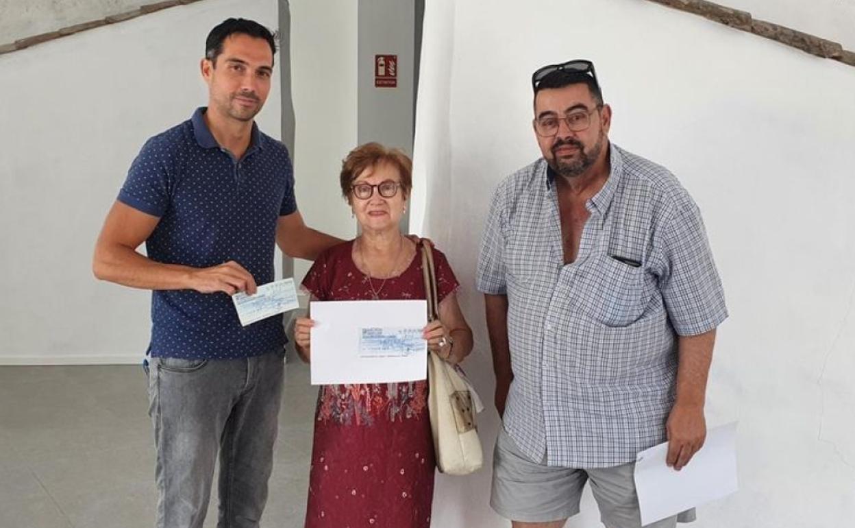 Isabel y Santiago entregan uno de los cheques al alcalde, Manolo Borrego