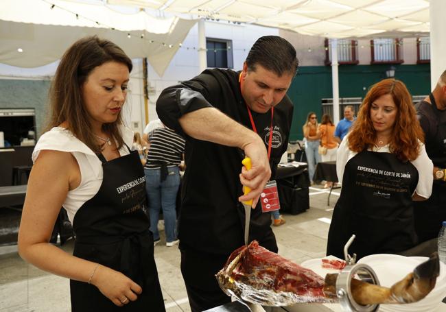 Dos valverdeñas aprendiendo a cortar jamón