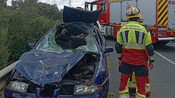 El helicóptero llega al lugar del accicente. En primer plano, un ombero junto al vehículo siniestrado