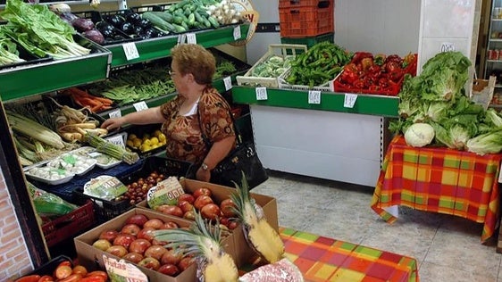 Una mujer mira alimentos en una frutería