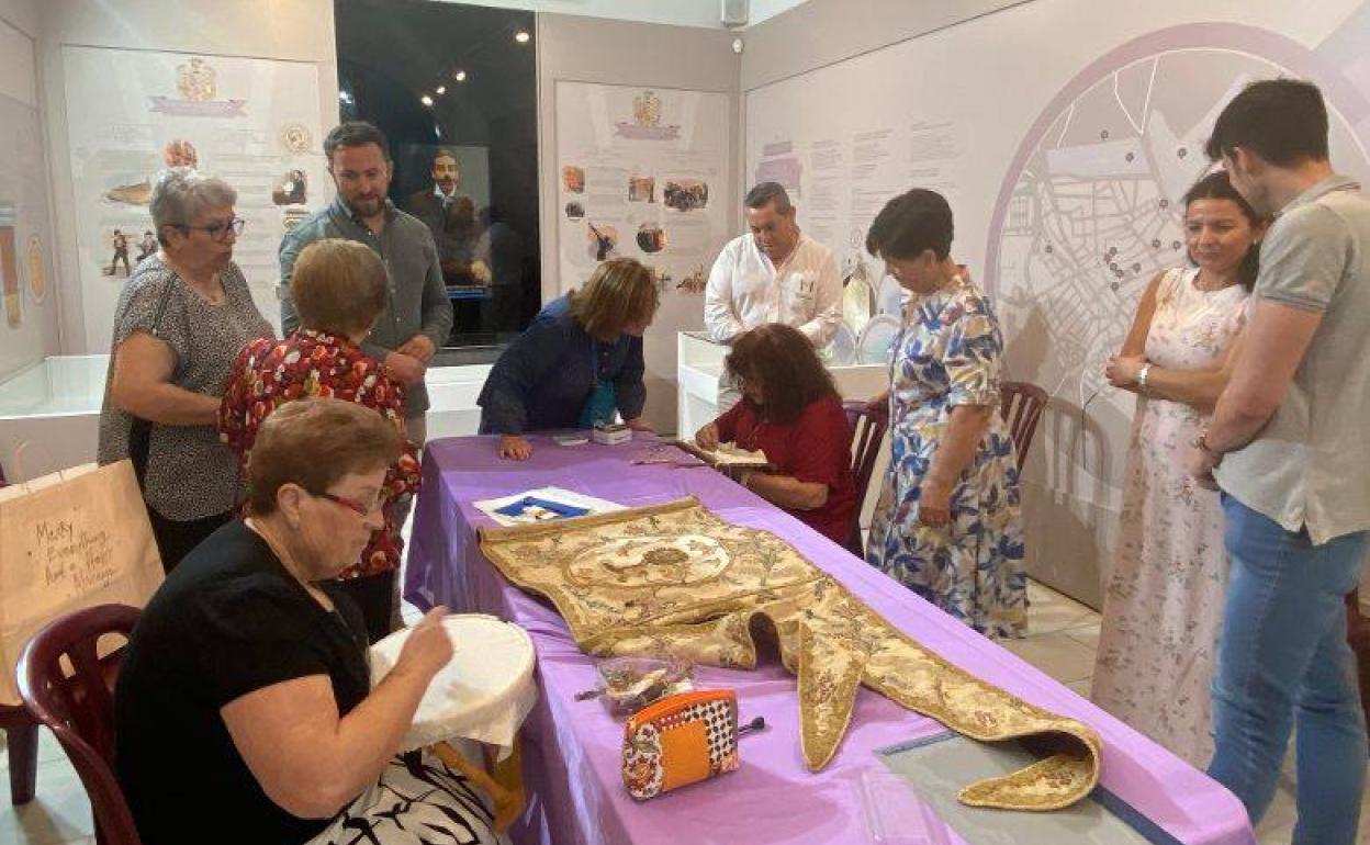 La asociación cultural y recreativa 'Últimas Bordadoras' replicando los bordados de un guion sacramental del S.XIX 