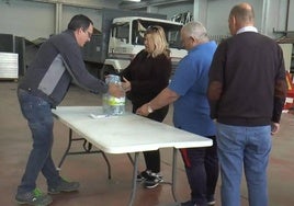 Vecinos de Villafranca recogen sus garrafas de agua en la calle Adelardo Covarsí.