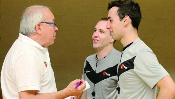 Vicente Sanchís charla con dos ábitros de baloncesto. 