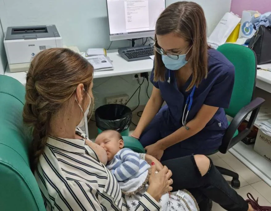 Una sanitaria atiende a una usuaria y su bebé en la consulta de lactancia materna. 