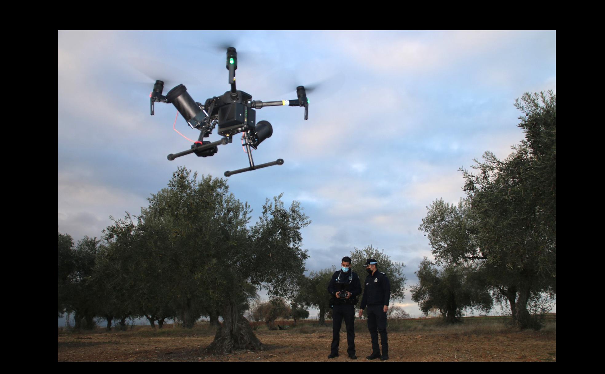 Dos agentes de Plicía Local hacen volar el dron para detectar delitos en el campo. 