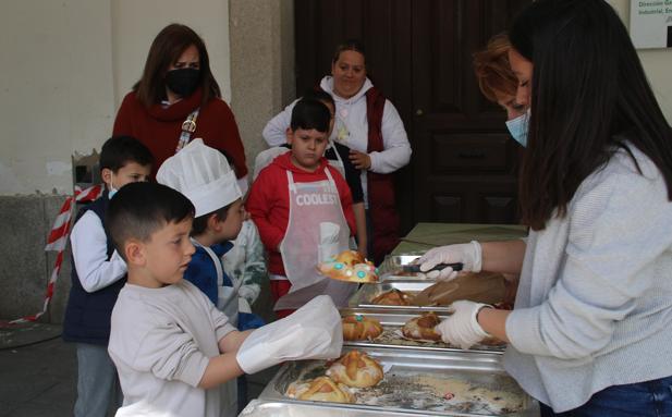 Un niño recoge su hornazo recién salido del horno. 