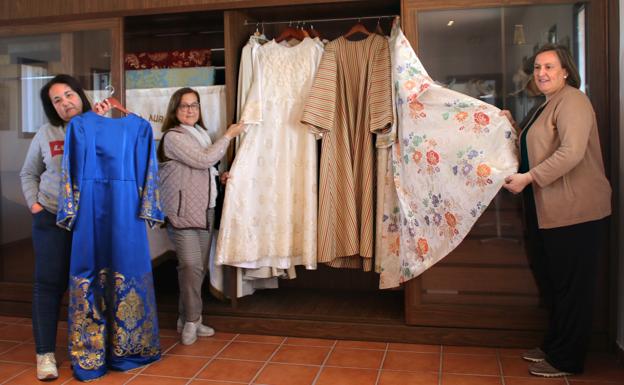 Las camareras muestran algunos de los trajes de la Virgen de la Aurora. 