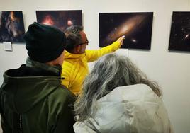 Juan Manuel García, autor de la muestra, explica algunas imágenes a dos visitantes.