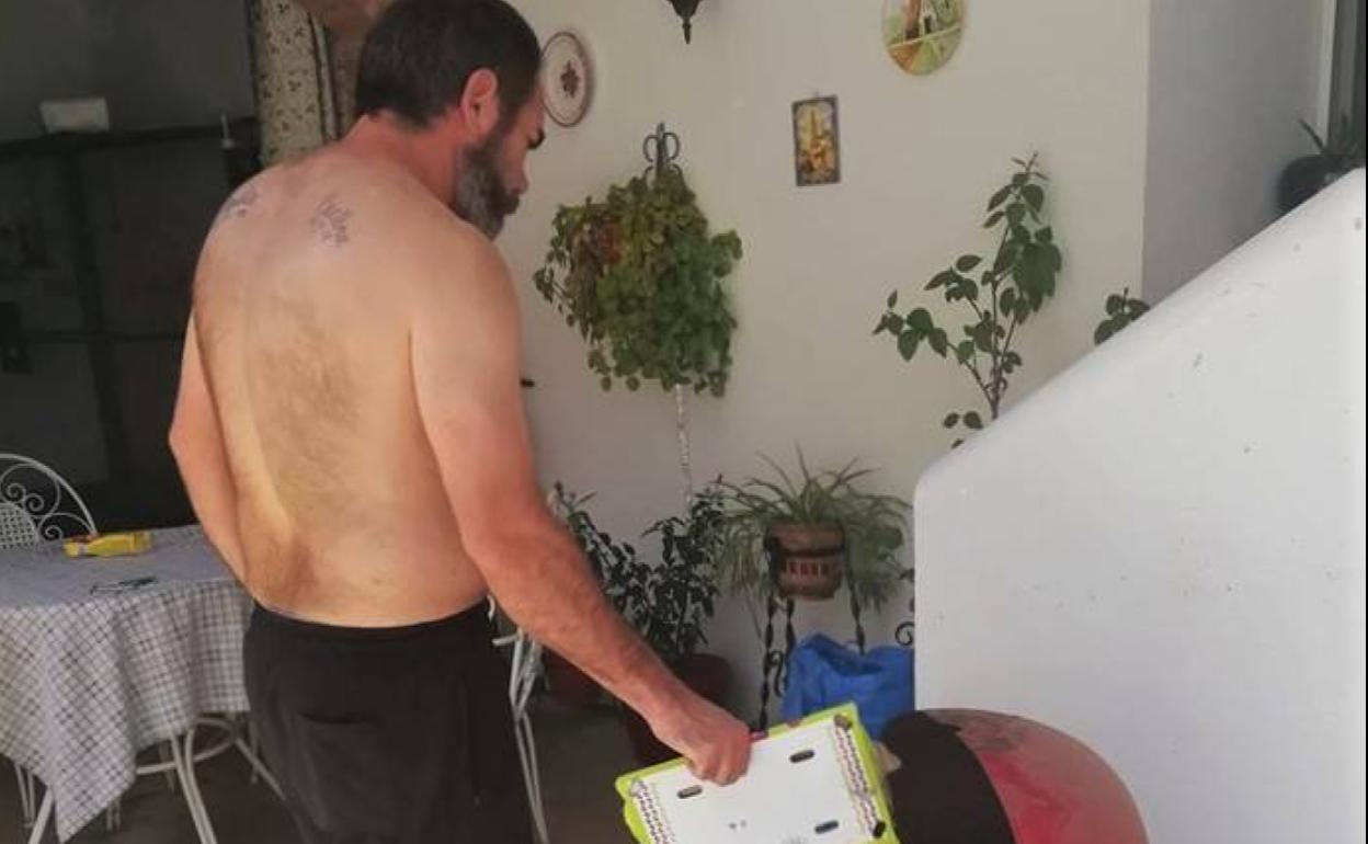 Un vecino enciende la barbacoa para celebrar en casa la romería. 