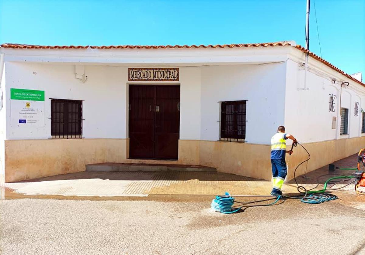 Un operario municipal limpia la fachada del mercado, imagen de archivo.