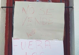 Carteles realizados por vecinos y colocados en la ventana de reparto de acciones.