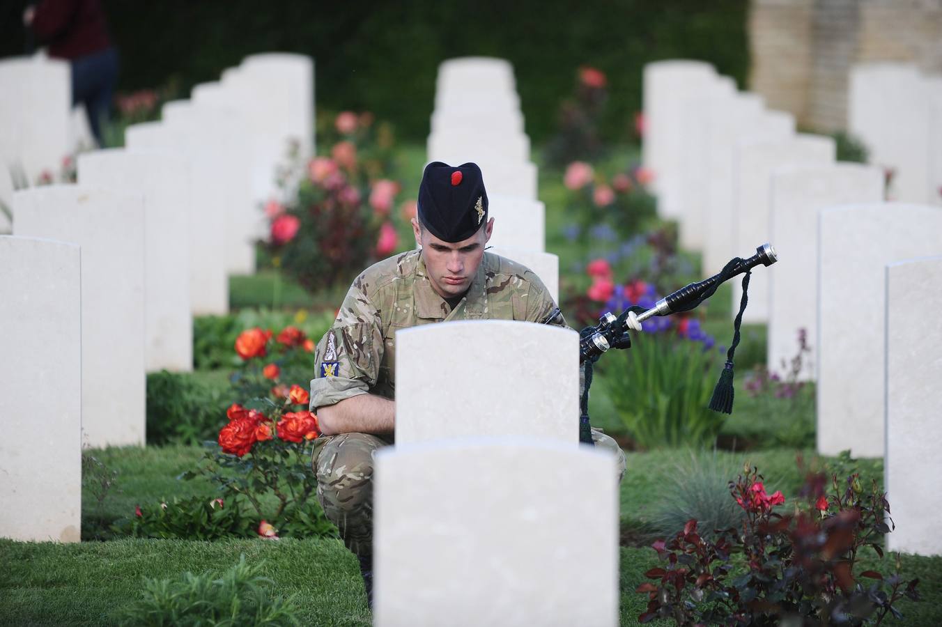 Un soldado británico presenta sus respetos en el cementerio militar de Ranville, al noroeste de Francia. AFP PHOTO / Jean-Sebastien Evrard.