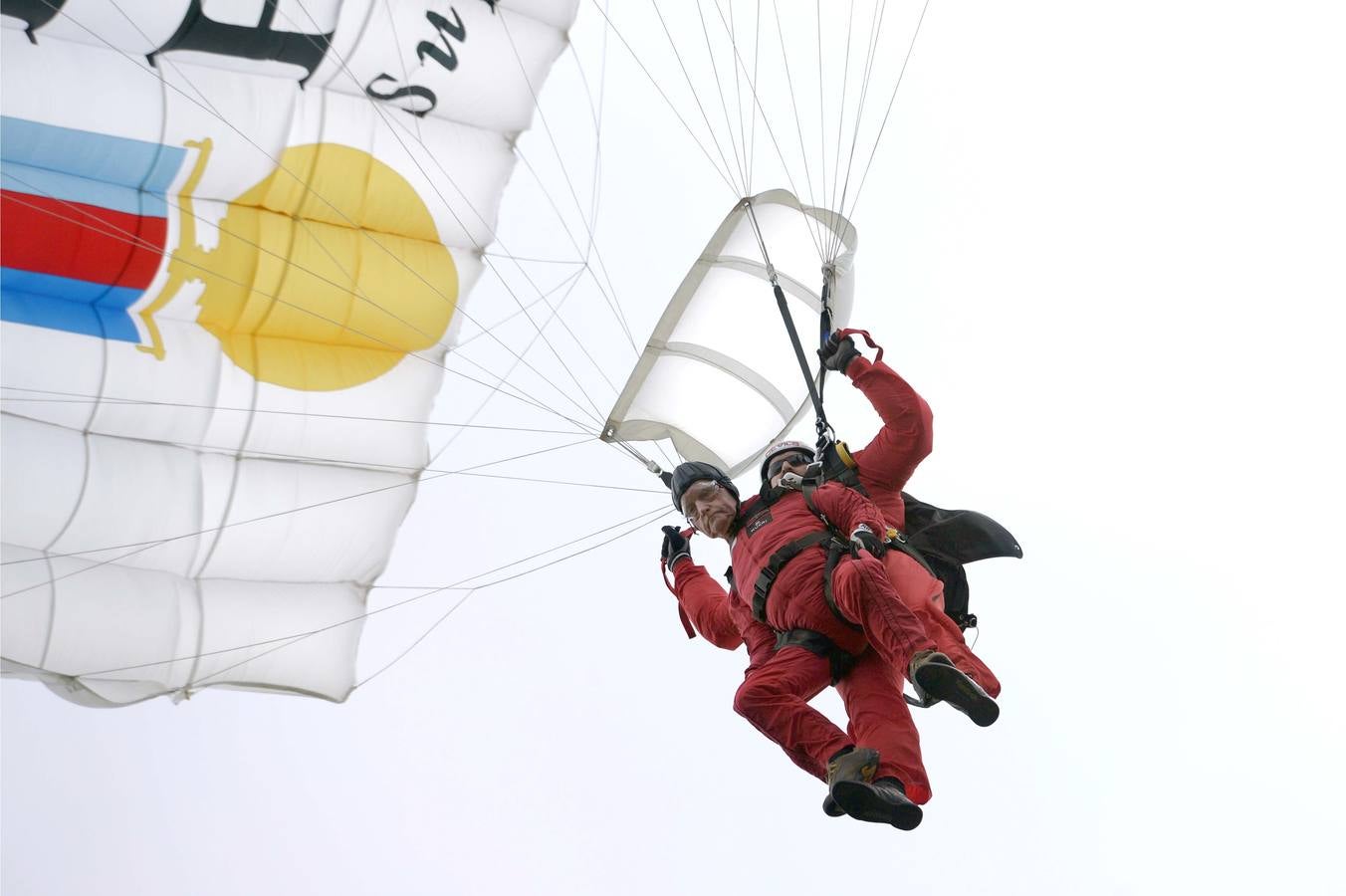 El veterano británico de la Segunda Guerra Mundial, Jock Hutton (Iz), de 89 años de edad, realiza un salto en tándem junto a miembro del equipo de paracaidistas de "Red Devils", en Ranville el norte de Francia. AFP PHOTO / THOMAS BREGARDIS