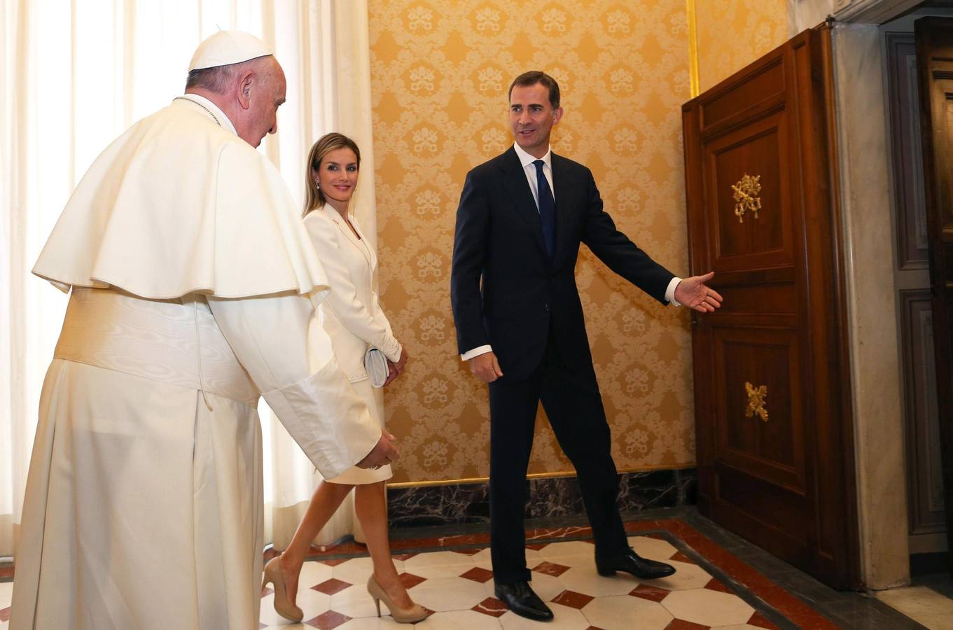 El rey Felipe VI (dcha) y la reina Letizia (centro) ceden el paso al papa Francisco.
