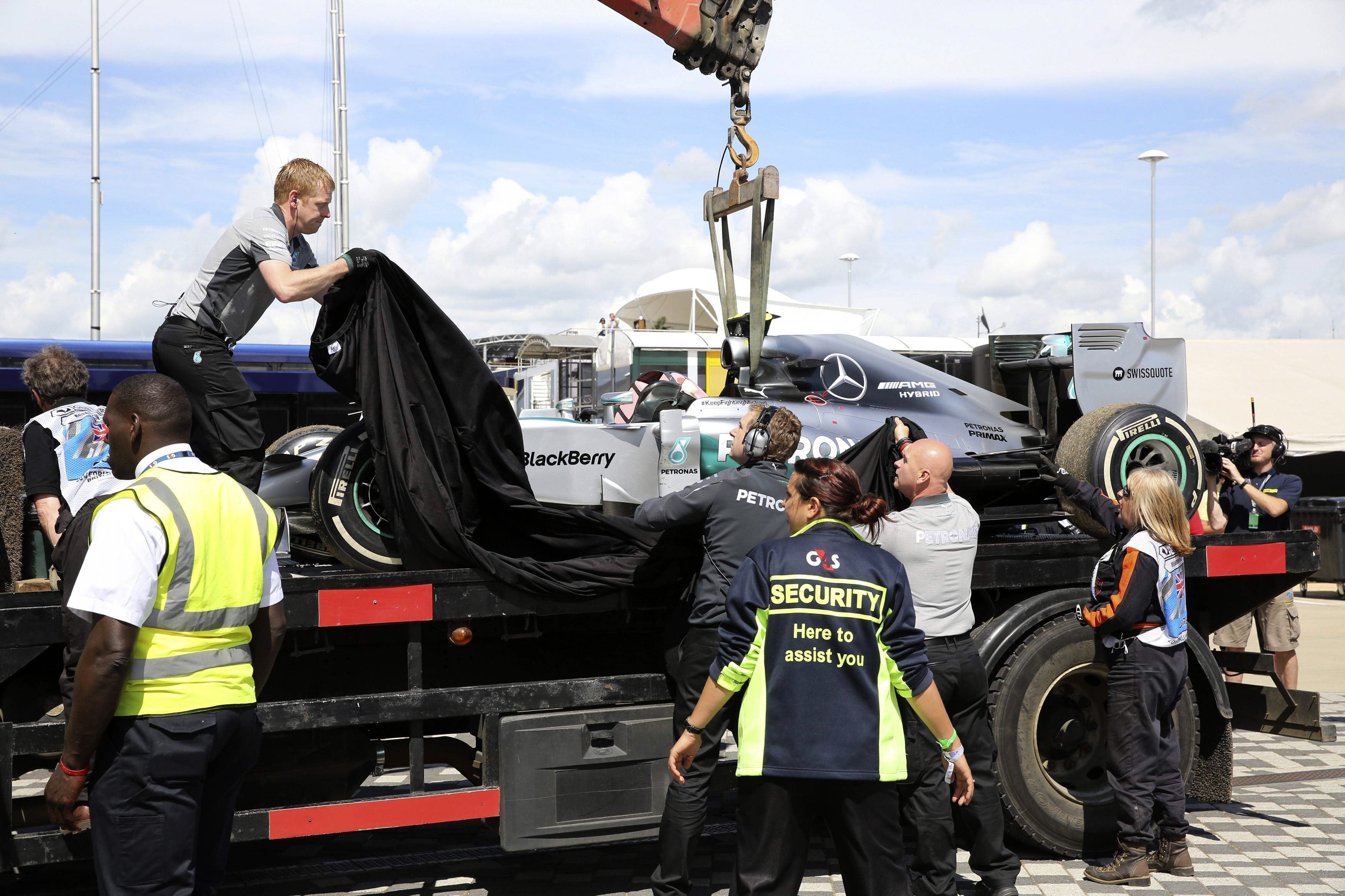 El monoplaza de Nico Rosberg es cubierto tras haberlo retirado de la pista.