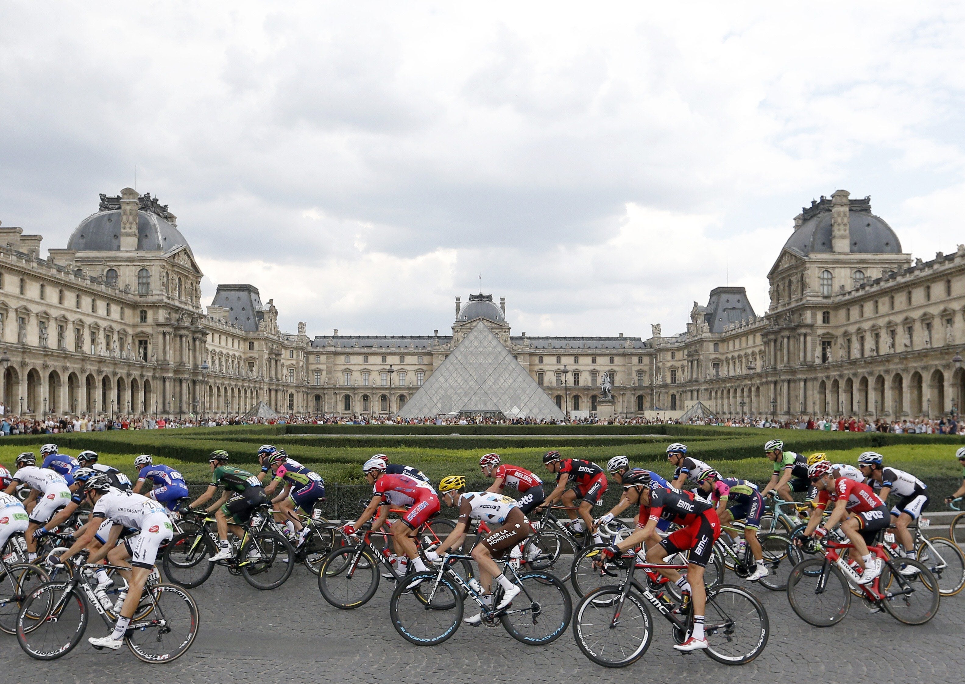 Corredores pasan por el Museo Louvre.
