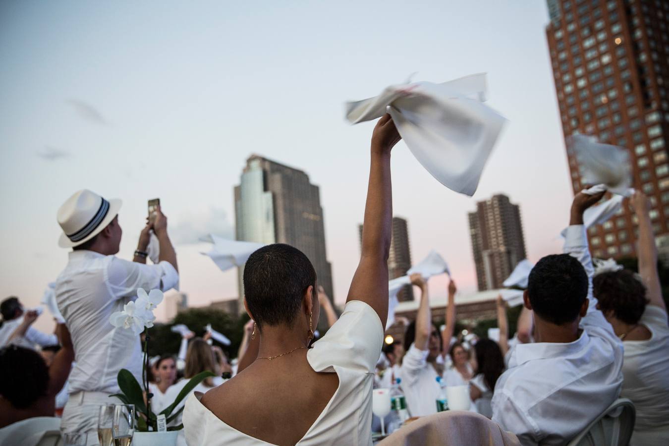 Lunes 25 de agosto: 'The Diner en Blanc' es único evento culinario viral del mundo. Celebra su 25 aniversario al aire libre y siempre un lugar histórico. Los invitados deben vestir de un elegante color blanco, llevar una cesta de picnic con comida, vajilla de porcelana y cubiertos, manteles blancos, mesas y sillas. En esta ocasión 'Battery Park City' ha acogido a unas 5.000 personas. Foto: Andrew Burton/AFP