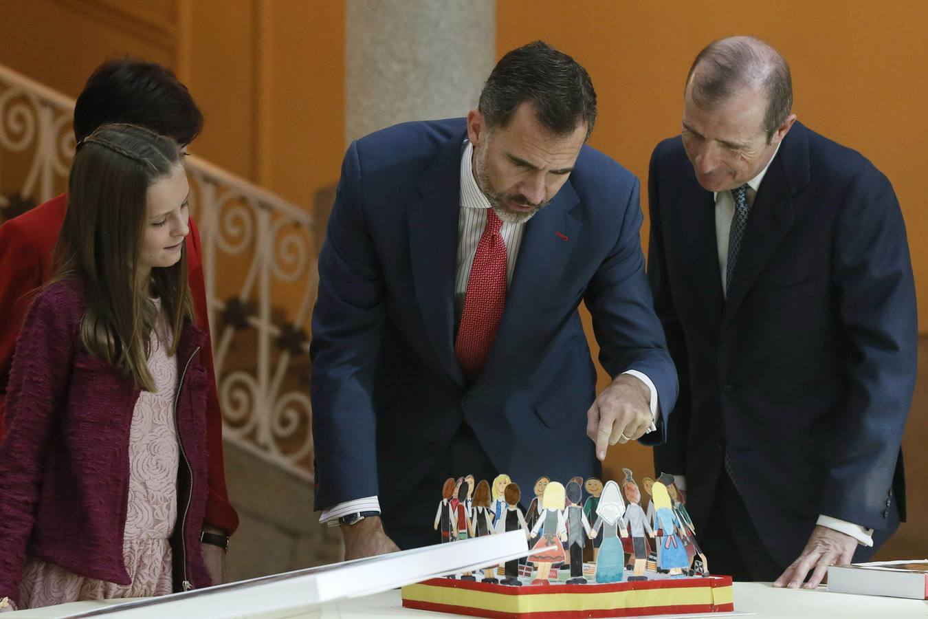 El rey Felipe VI observa el trabajo de una de las niñas ganadoras de la XXXII y XXXIII edición del concurso escolar '¿Qué es un rey para ti?'.