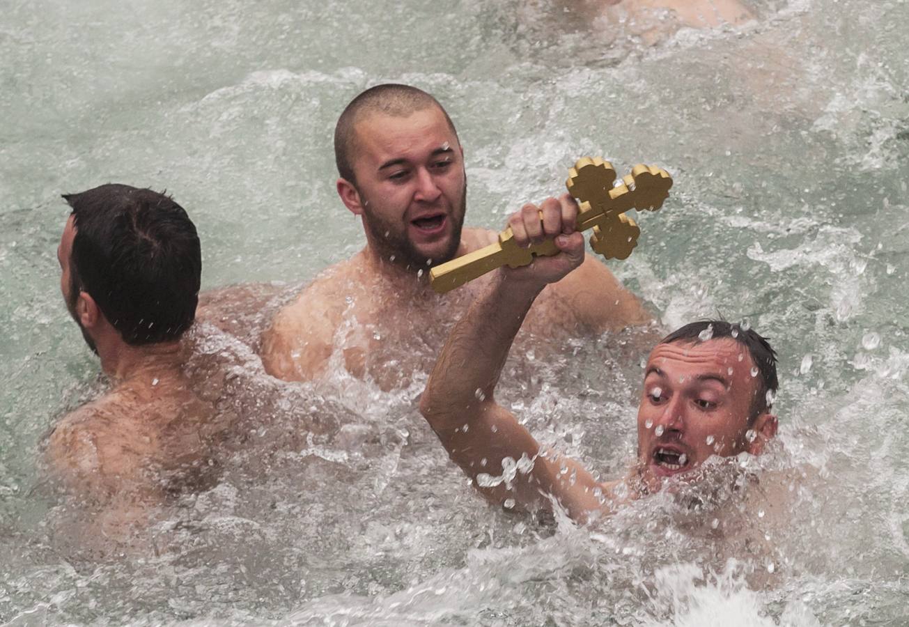 Mirko Kovacevic, de 28 años, levanta la cruz tras lograr recuperarla del río Ribnica durante las celebraciones de la festividad de la Epifaníaen Podgorica, Montenegro. Fotografía: REUTERS- Stevo Vasiljevic.
