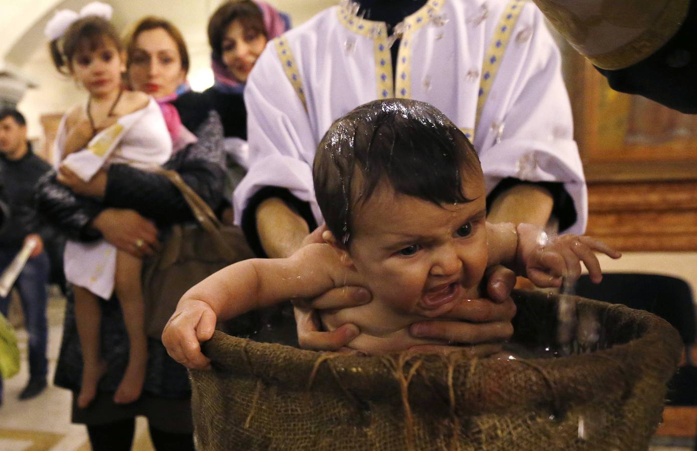 Bebés bautizados durante una ceremonia de bautismo en masa en el día de la Epifanía en Tbilisi. Alrededor de 1.000 niños fueron bautizados por la Iglesia Ortodoxa de Georgia durante la 38ª ceremonia de bautismo en masa en la catedral principal del país. REUTERS / David Mdzinarishvili