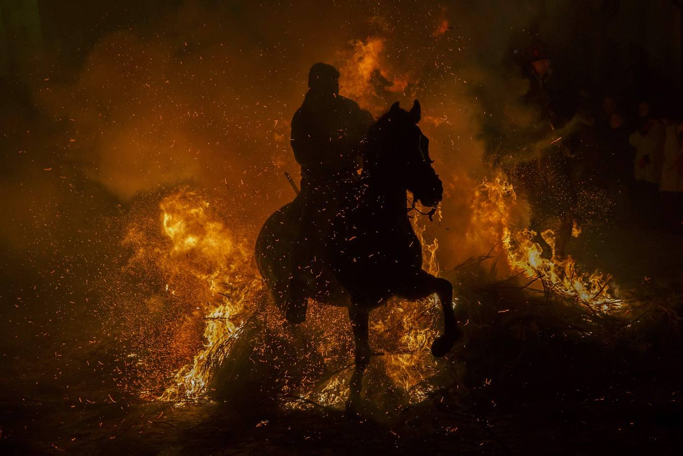 Sábado, 17 de enero: La pequeña localidad abulense de San bartolomé de Pinares volvió a vivir una noche mágica, sumergida bajo una espesa nube de humo que sirvió para purificar al centenar de caballos que pasó por la veintenas de luminarias distribuidadas por las empinadas calles del pueblo. Fotografia: Juan Medina / Reuters