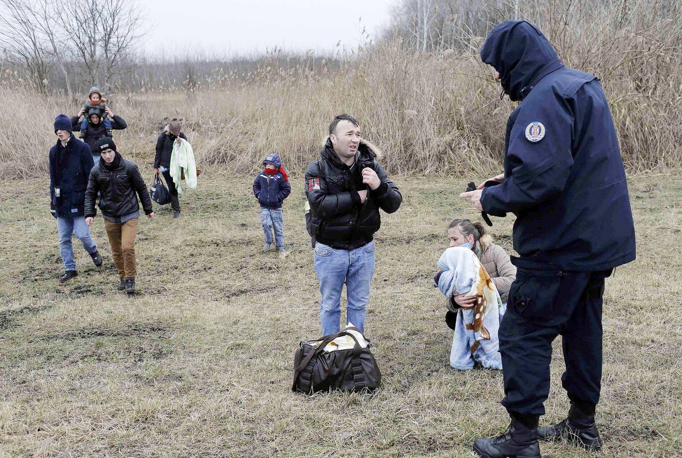 Una mujer kosovar sostiene a su hijo antes de montarse en un vehículo de la policía de fronteras de Serbia tras ser detenidos cerca de la ciudad de Subotica. al tratar de intentar pasar ilegalmente a Hungría. Fotografía: REUTERS / Marko Djurica
