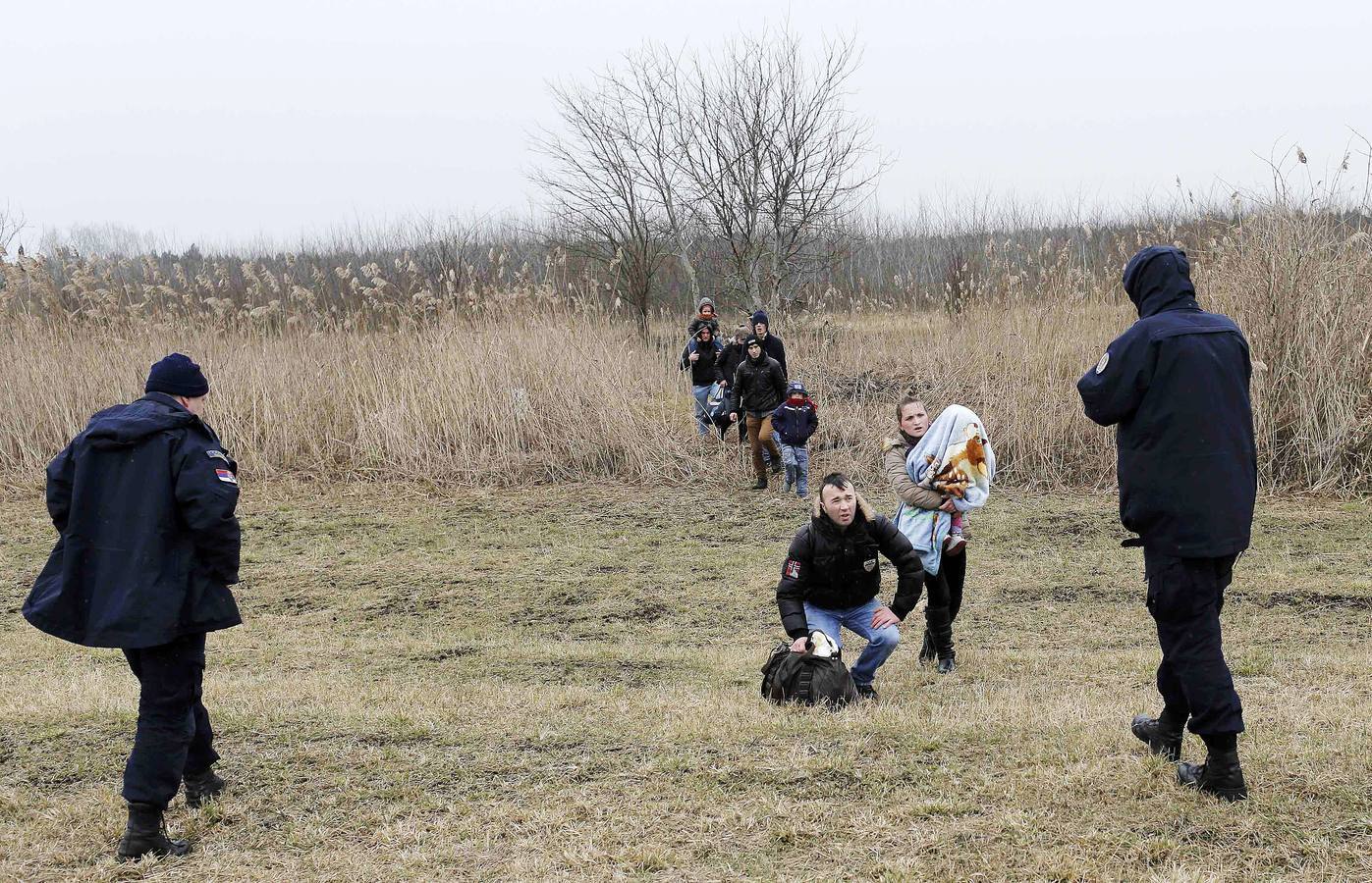 Una mujer kosovar sostiene a su hijo antes de montarse en un vehículo de la policía de fronteras de Serbia tras ser detenidos cerca de la ciudad de Subotica. al tratar de intentar pasar ilegalmente a Hungría. Fotografía: REUTERS / Marko Djurica