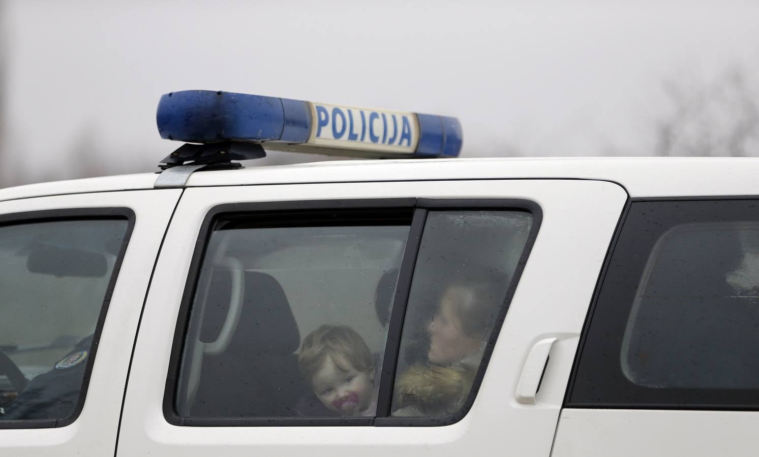 Una mujer kosovar sostiene a su hijo antes de montarse en un vehículo de la policía de fronteras de Serbia tras ser detenidos cerca de la ciudad de Subotica. al tratar de intentar pasar ilegalmente a Hungría. Fotografía: REUTERS / Marko Djurica