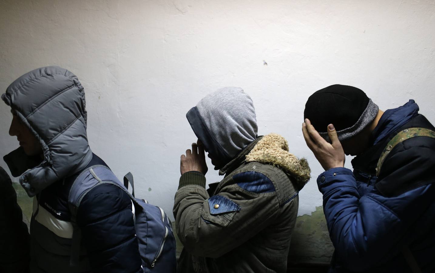 Un grupo de ciudadanos de Kosovo espera en una comisaria de policía después de que fueran detenidos cuando trataban de cruzar la frontera a Hungría, en la ciudad de Subotica. Fotografía: REUTERS / Marko Djurica