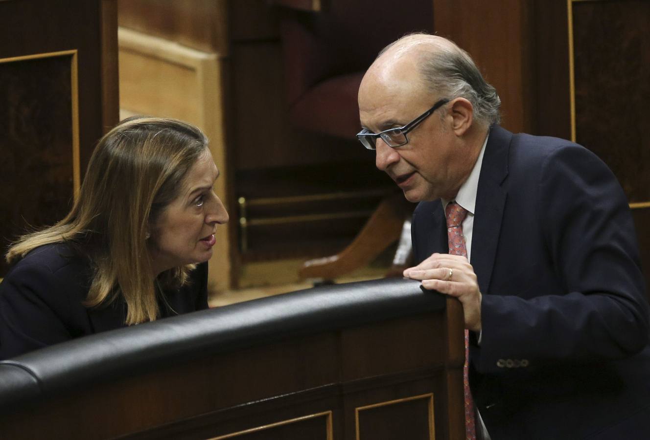 Expectación entre los ministros. El ministro de Hacienda, Cristóbal Montoro, conversa con la ministra de Fomento, Ana Pastor, durante la sesión de la tarde en el Congreso.