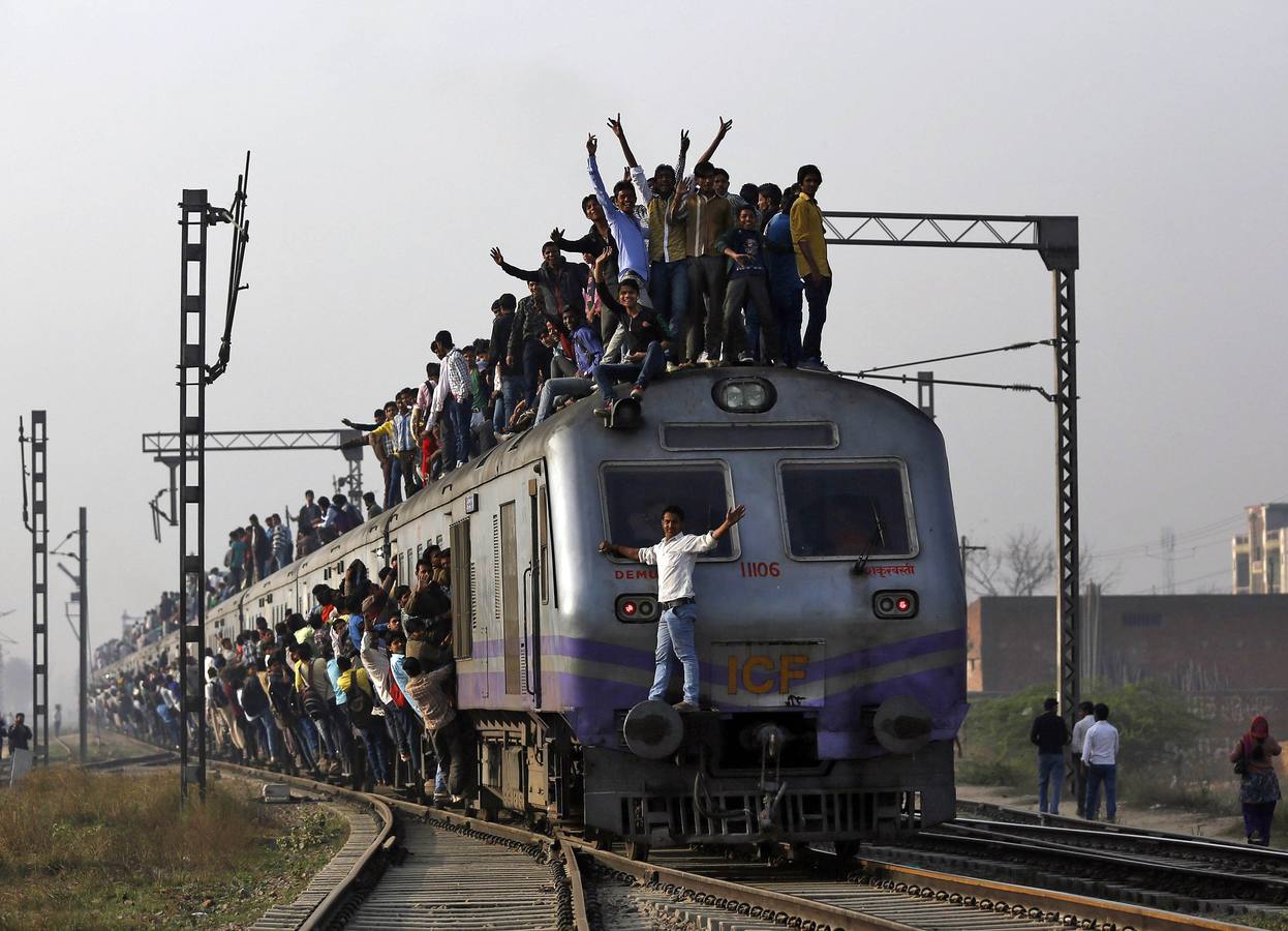 Los pasajeros viajan en un tren abarrotado en las afueras de Nueva Delhi