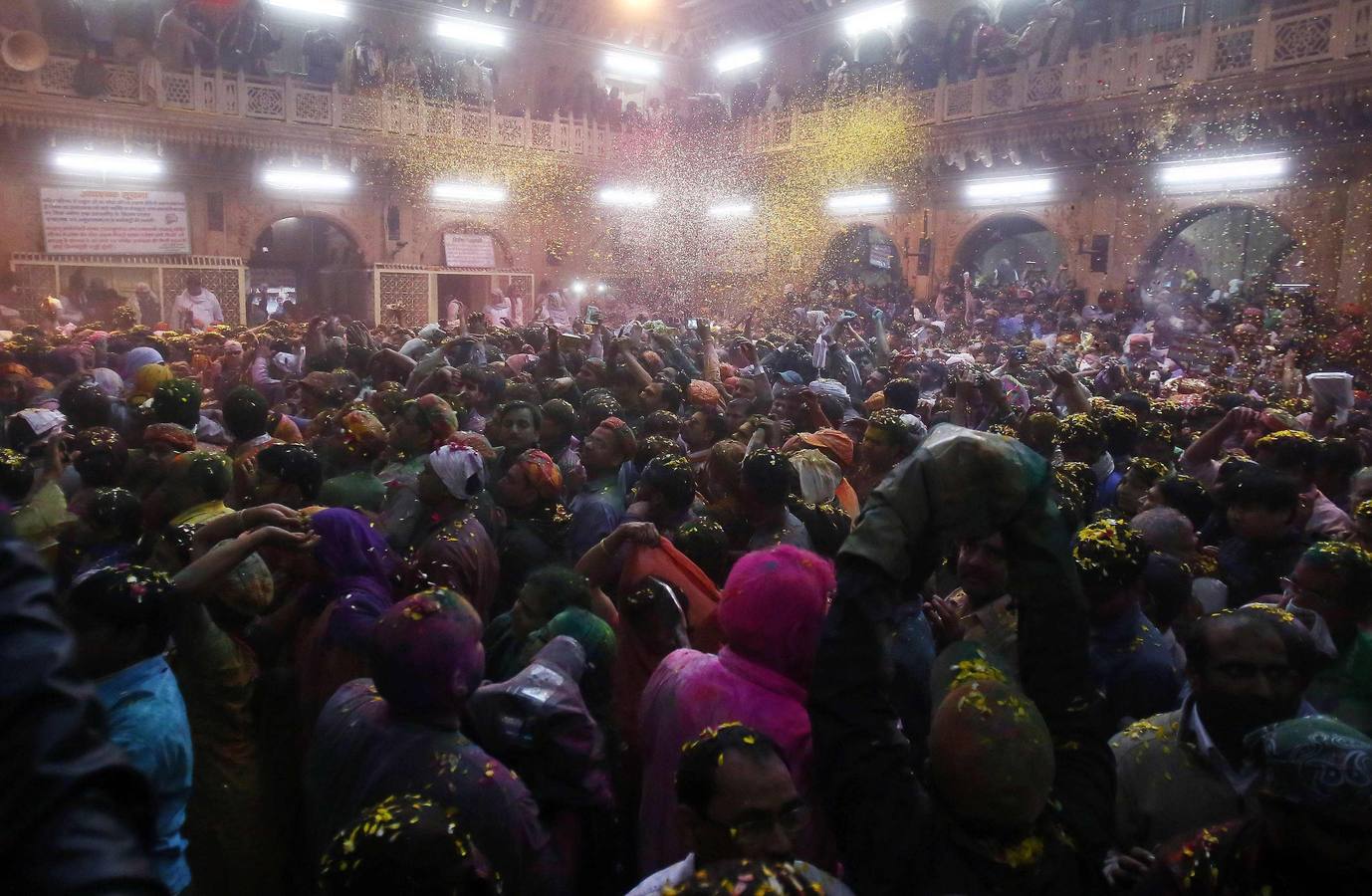 Devotos hindúes reciben una lluvia de pétalos en el interior del templo Bankey Bihari,en Vrindavan. Fotografía: Reuters / Anindito Mukherjee.