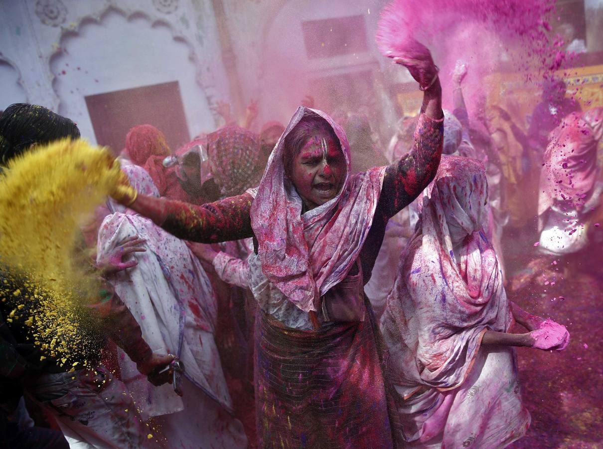 Mujeres viudas de Vrindavan pintarrajeadas en colores toman parte en las celebraciones de Holi, organizado por la organización no gubernamental Sulabh Internacional. Fotografía: Reuters/ Ahmad Masood.