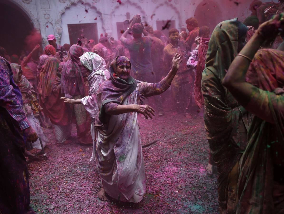 Mujeres viudas de Vrindavan pintarrajeadas en colores toman parte en las celebraciones de Holi, organizado por la organización no gubernamental Sulabh Internacional. Fotografía: Reuters / Ahmad Masood.