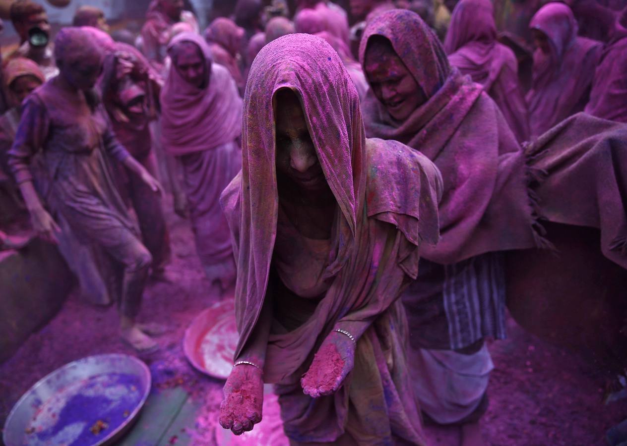 Mujeres viudas de Vrindavan pintarrajeadas en colores toman parte en las celebraciones de Holi, organizado por la organización no gubernamental Sulabh Internacional. Fotografía: Reuters / Ahmad Masood.