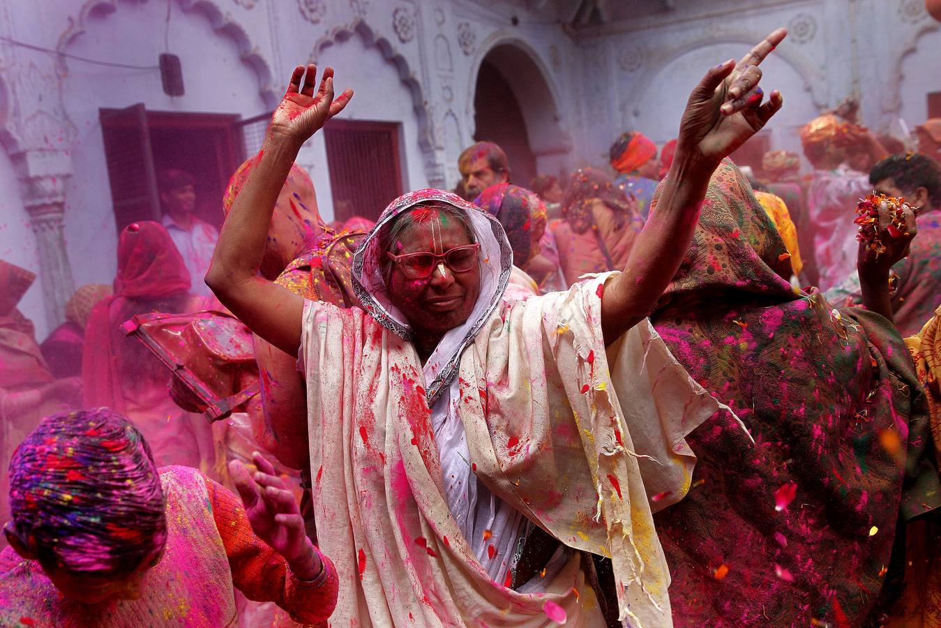 Mujeres viudas de Vrindavan pintarrajeadas en colores toman parte en las celebraciones de Holi, organizado por la organización no gubernamental Sulabh Internacional. Fotografía: EFE / Harish Tyagi