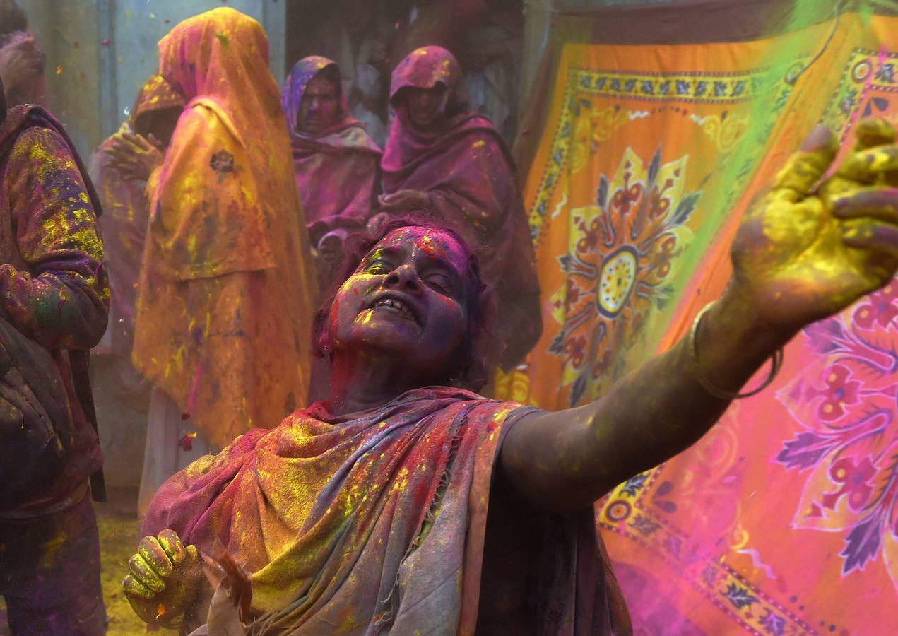 Mujeres viudas de Vrindavan pintarrajeadas en colores toman parte en las celebraciones de Holi, organizado por la organización no gubernamental Sulabh Internacional. Fotografía: AFP / Roberto Schmidt