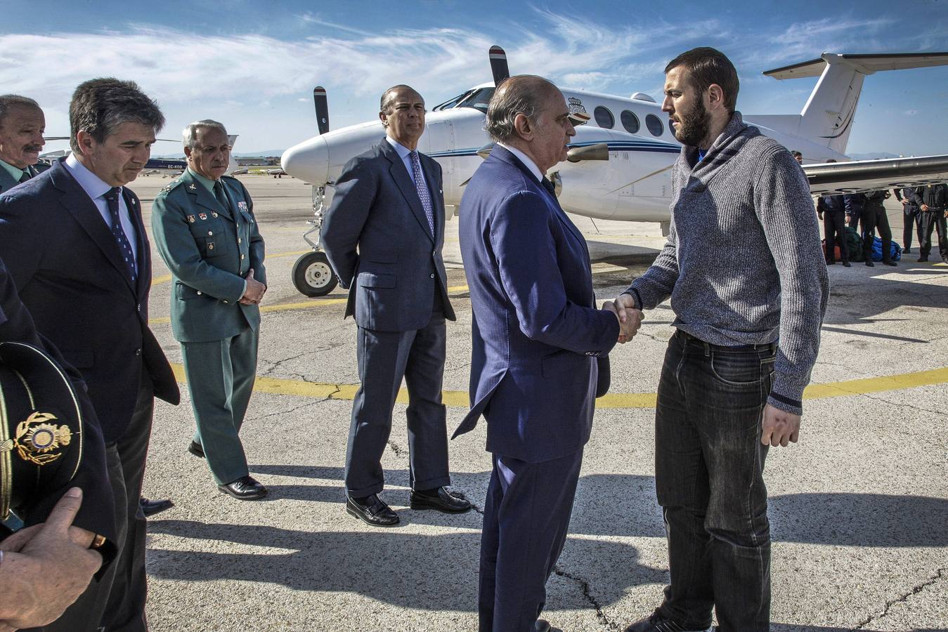 Martes, 7 de abril. Jorge Fernández Díaz (c), recibiendo al policía nacional y espeleólogo Juan Bolívar Bueno (d), a su llegada al aeródromo de Cuatro Vientos de Madrid, procedente de Uarzazate (Marruecos), en el avión fletado por la Policía tras el accidente en el que fallecieron otro agente y un abogado españoles. Fotografías: EFE