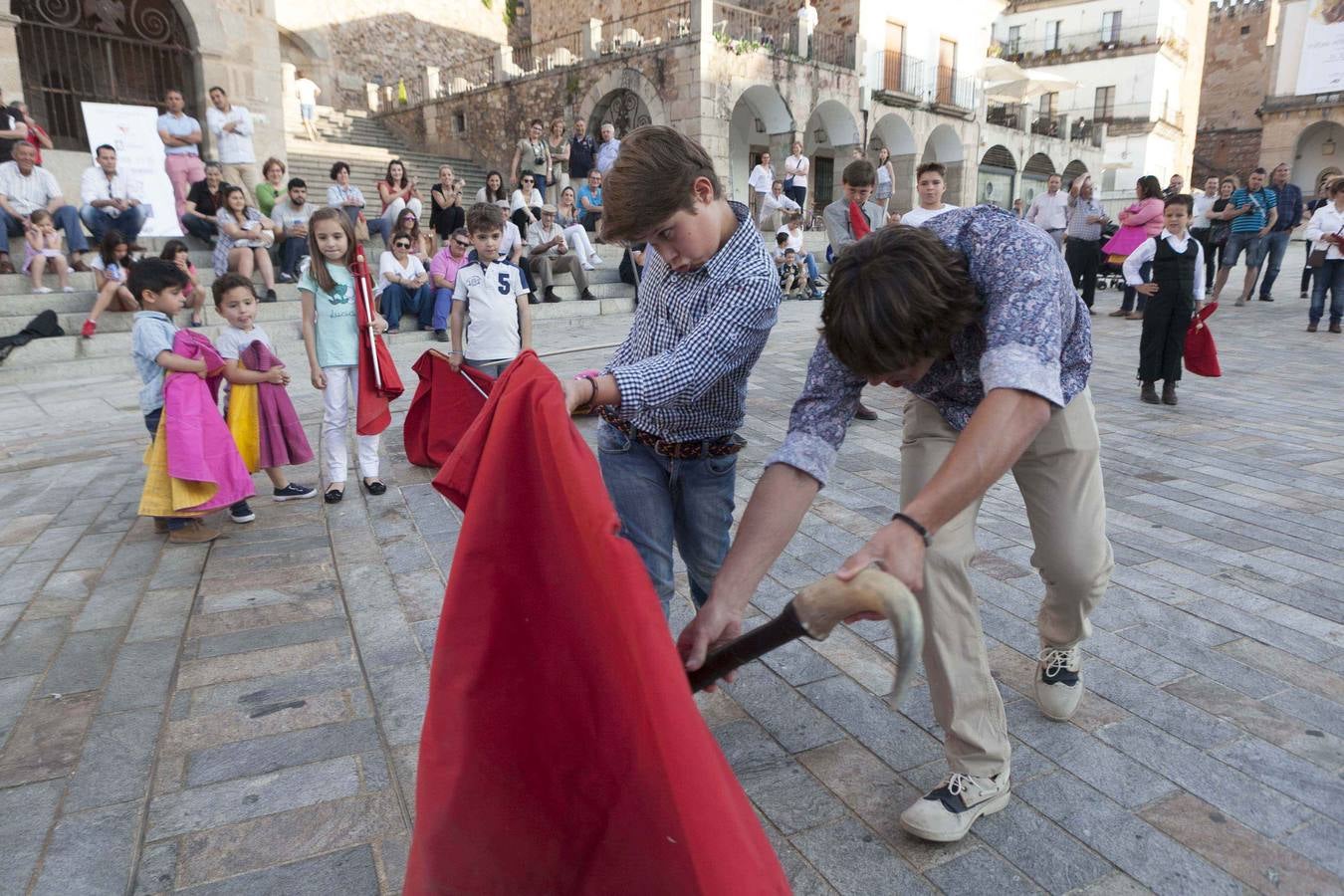Jueves, 14 de mayo: El matador de toros cacereño Manolo Bejarano dirigió en la Plaza Mayor de Cáceres, una clase práctica de toreo de salón en la que participaron decenas de niños que, asidos a sus muletas y capotes, deleitaron a cuantos se acomodaron en las escaleras del Arco de la Estrella para contemplar tan inusual estampa. Fotografías: Jorge Rey