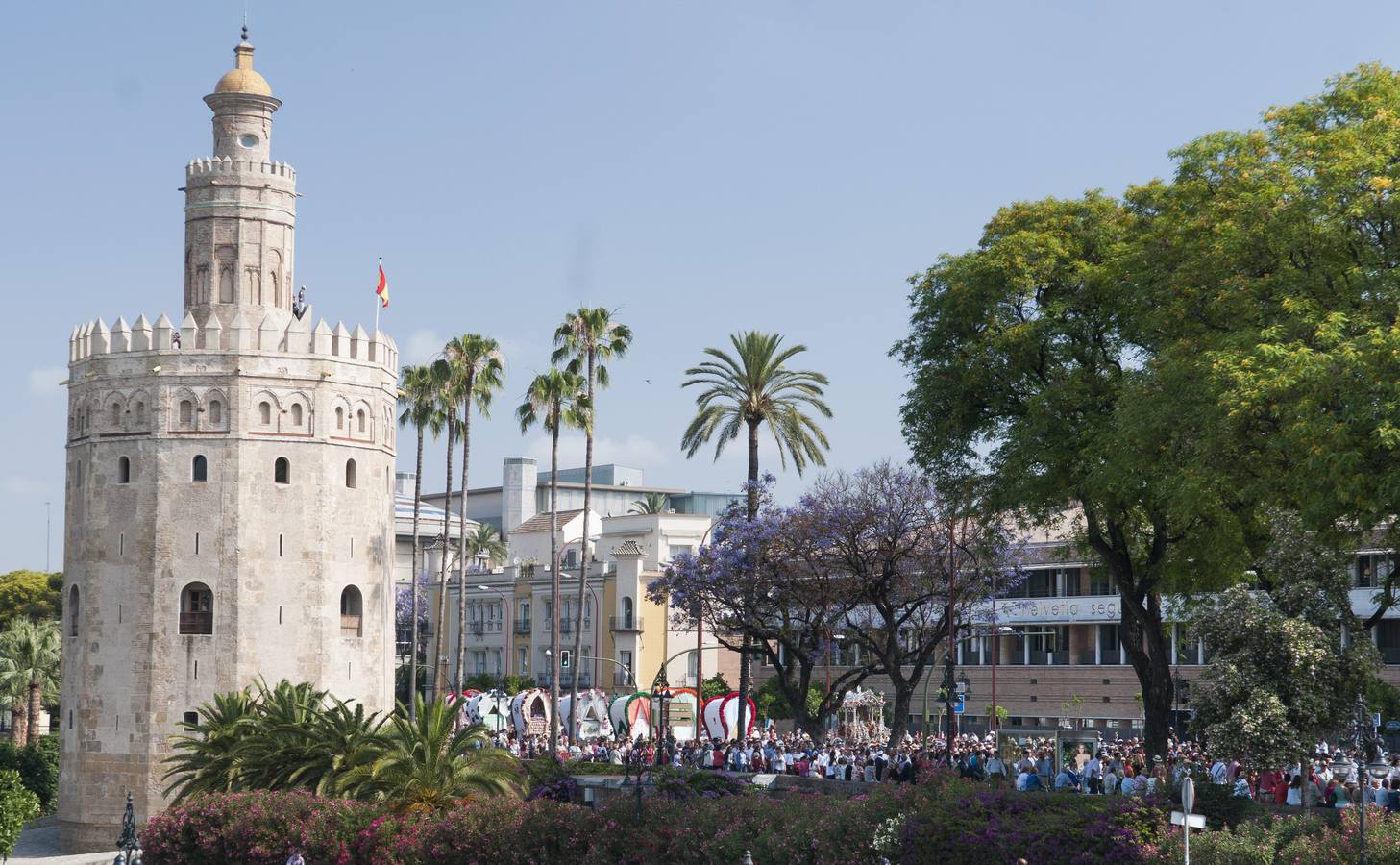 La Hermandad sevillana de El Salvador a su paso por la Torre del Oro en la capital hispalense, tras iniciar esta mañana su camino hacia la aldea almonteña de El Rocío (Huelva)