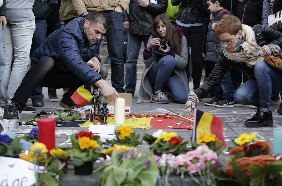 Decenas de personas depositan flores, velas y mensajes en la Place de la Bourse, en Bruselas, tras los atentados.