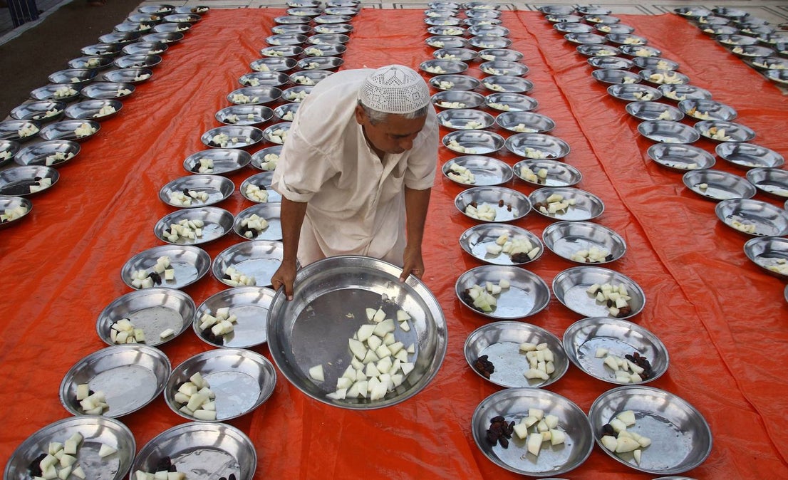 Un hombre sirve comida a los participantes para el Iftar, el momento para romper el ayuno, durante la celebración del Ramadán en Karachi (Pakistán)