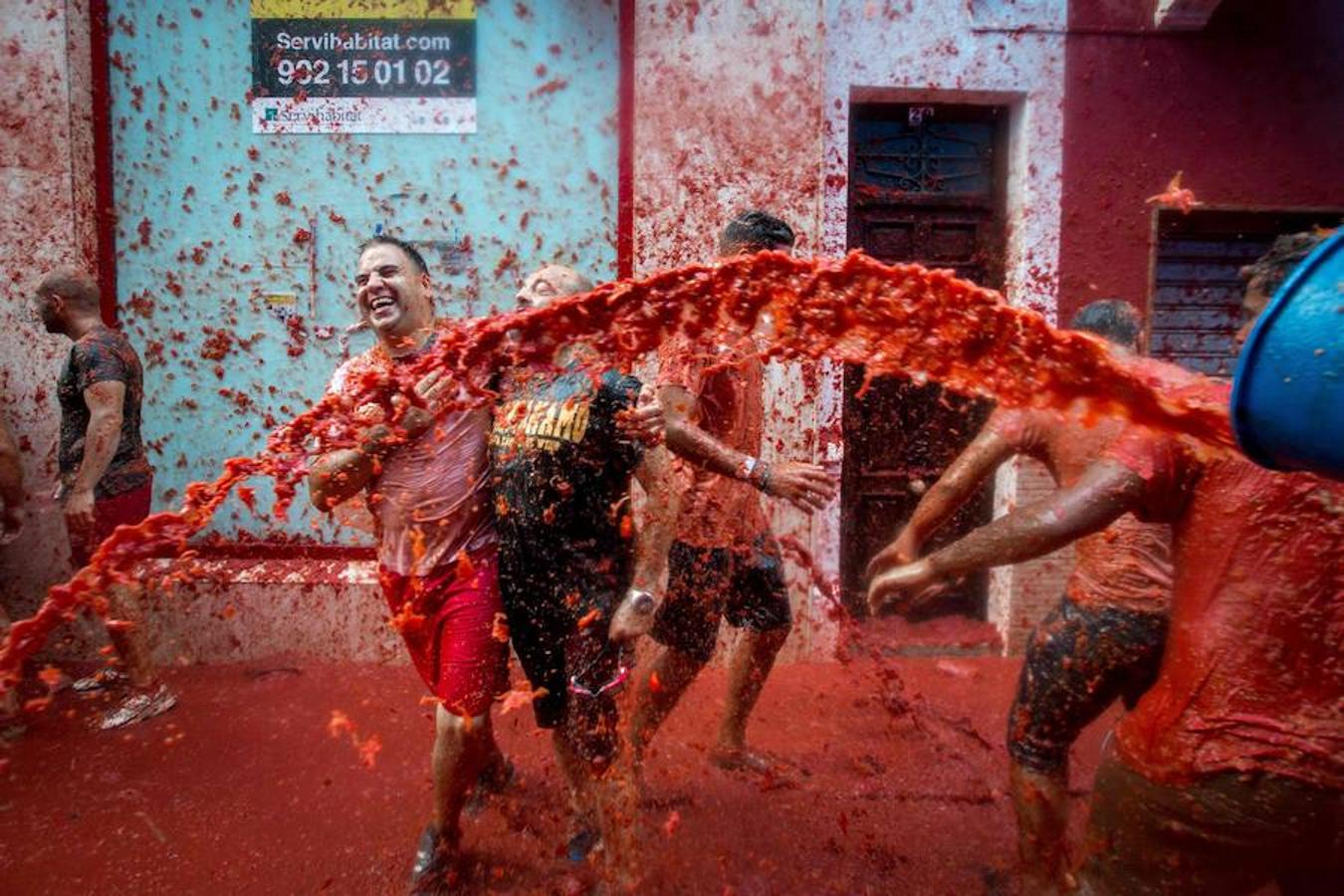 Miércoles, 31 de agosto: Buñol cumplió con la tradición de más de siete décadas. Miles de personas llegadas de todo el mundo se lanzaron 160 toneladas de tomate que tiñeron de rojo el municipio y se reinvindicó la lucha contra la violencia machista y la homofobia.. Fotografías: Agencias