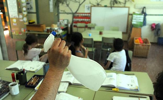 Un profesor del colegio José María Calatrava de Mérida refresca con un vaporizador a alumnos. :: / BRÍGIDO