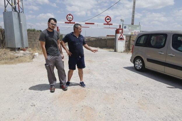 Jorge Cortés y Jerónimo Regodón, del polígono ganadero, en una de las entradas, sin asfaltar. :: 