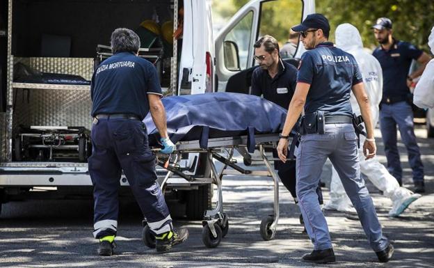 Varios miembros de la policía forense italiana se llevan los restos del cadáver.