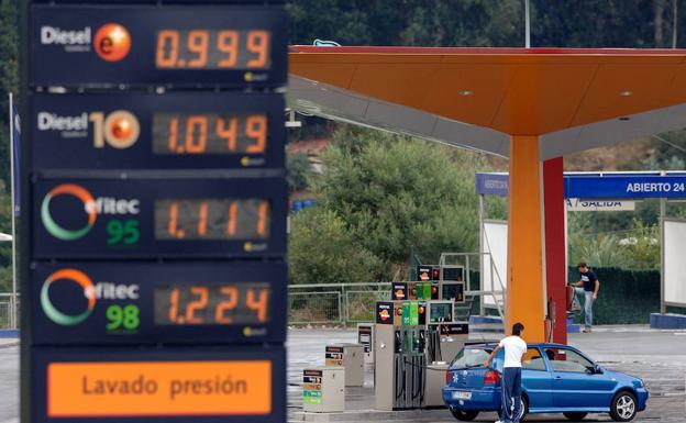 Cartel con los precios del combustible, ante una gasolinera. 