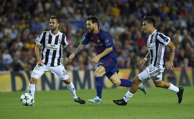 Messi conduce la pelota, presionado por Dybala. 