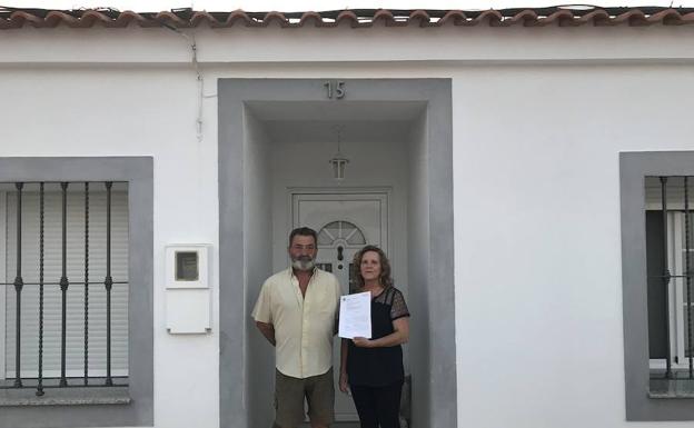 José Merchán y Manuela Blanco muestran la sentencia en la puerta de su casa de Guadiana del Caudillo:: HOY